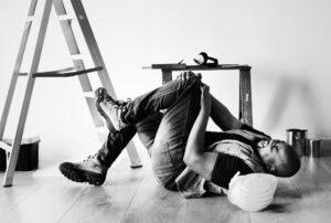 אובדן כושר עבודה - עובד בניין שוכב על הרצפה עם כאבים ברגל